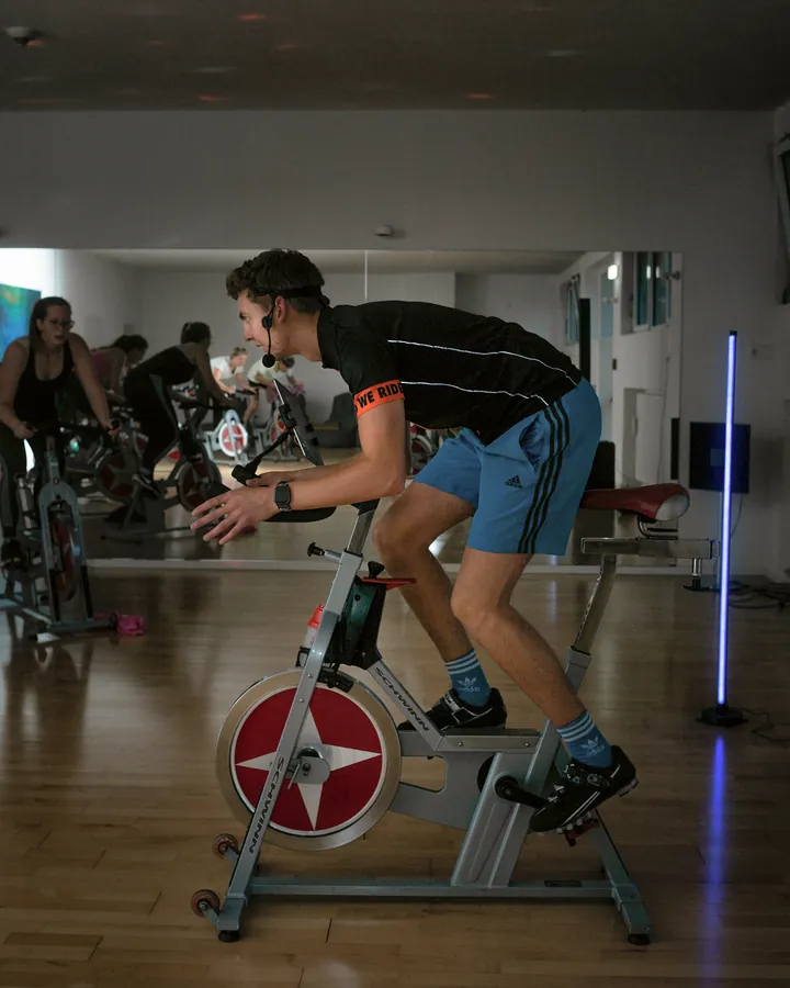 Trainer gibt auf dem Indoor Bike das Tempo für die Gruppe vor
