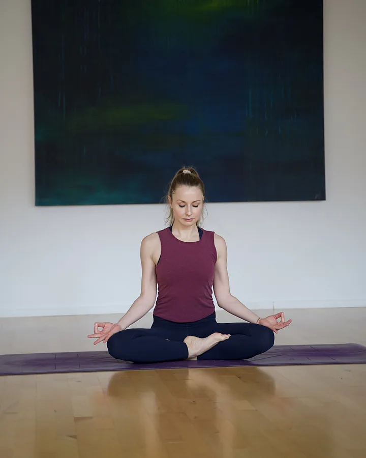 Yoga-Trainerin im Schneidersitz bei der Meditation